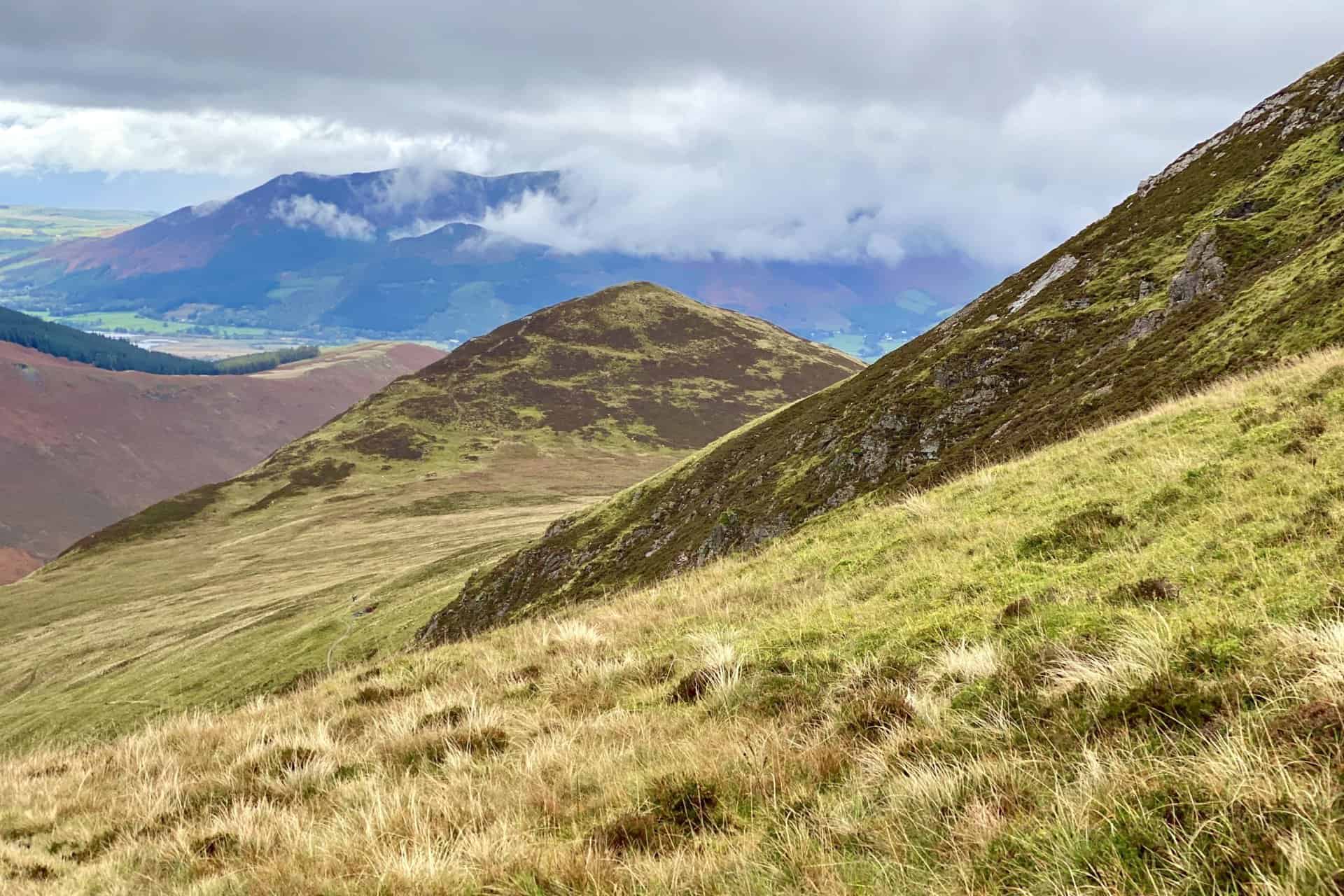The view of Outerside from the col between Sail and Causey Pike. In the distance is the Skiddaw range of mountains. Skiddaw, Carl Side and Little Man are cloud-covered, but Dodd, Long Side and Ullock Pike can be seen.