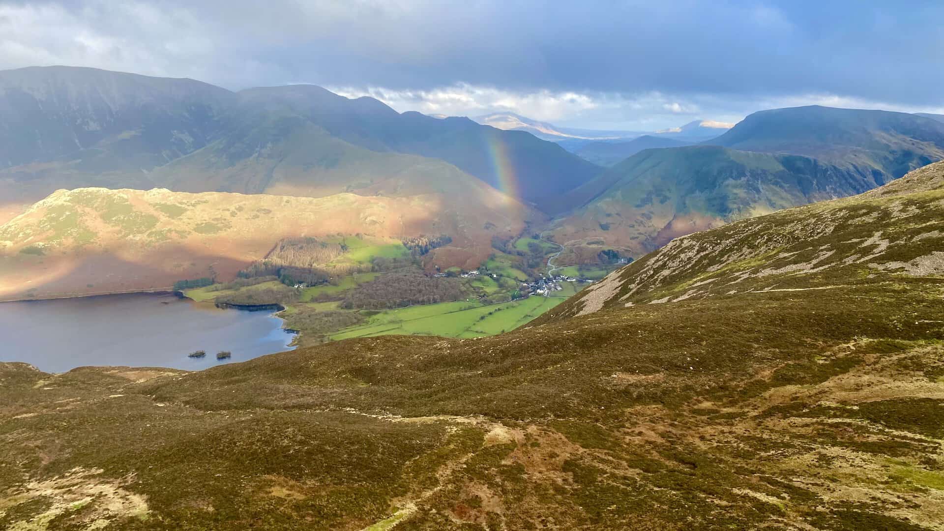 The sun lights up Rannerdale Knotts and a rainbow appears above Buttermere (the village).