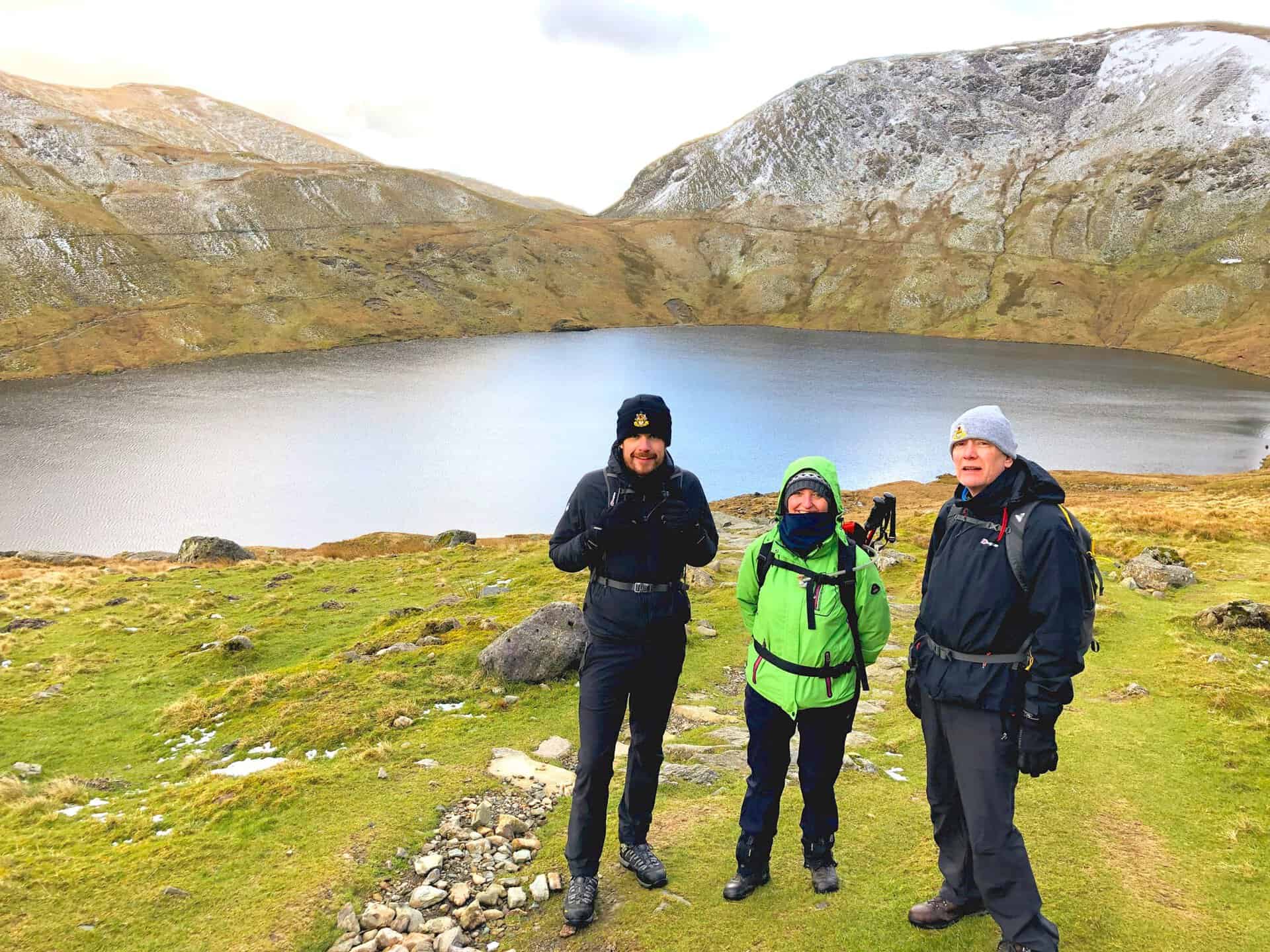 Pausing for a photo with the serene backdrop of Grisedale Tarn. Approximately twoe-thirds of the way round this Helvellyn walk from Glenridding.