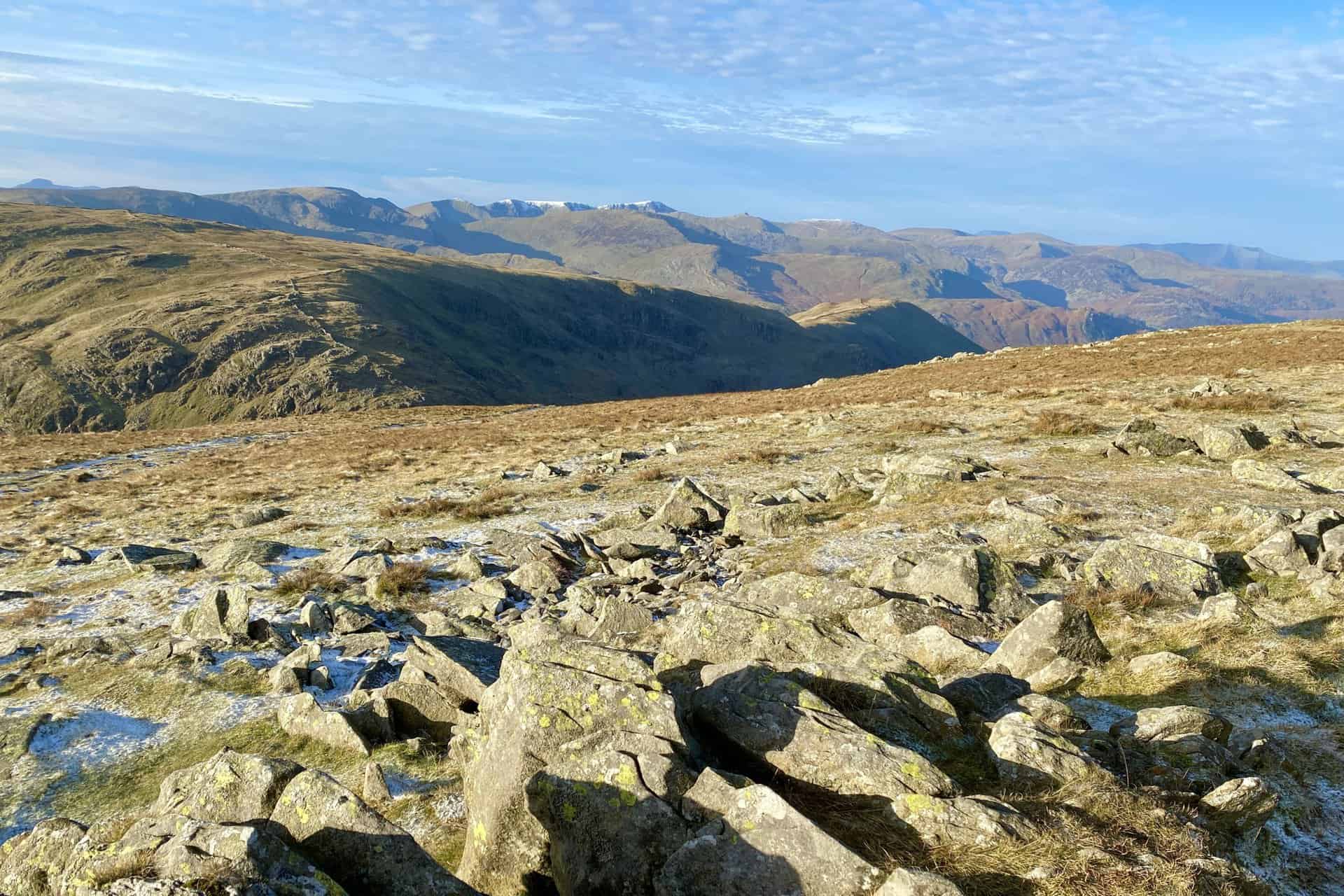 The view west from Thornthwaite Crag to the snow-covered tops of Helvellyn and Nethermost Pike on the horizon.