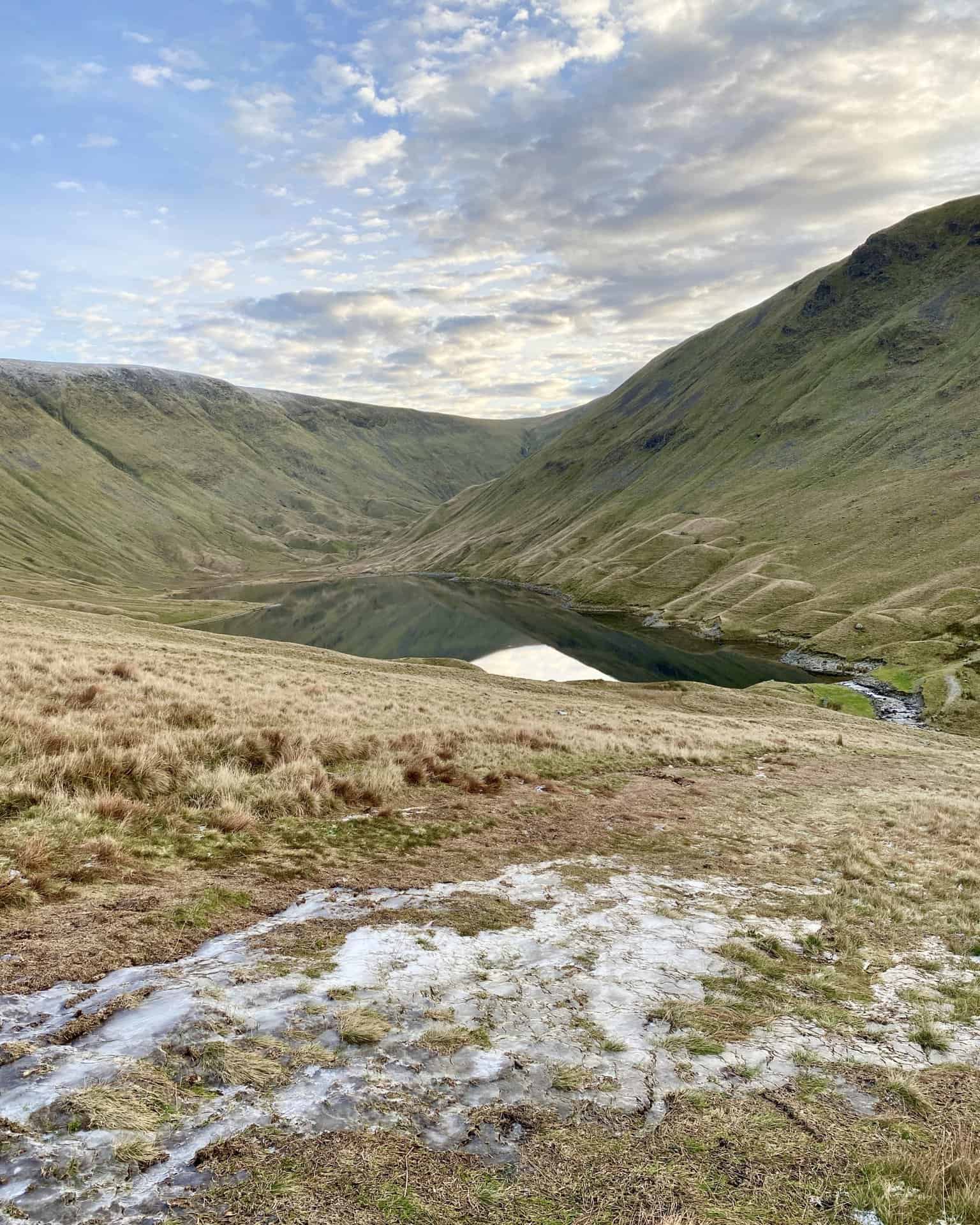 Hayeswater nestled in the valley at the foot of Gray Crag (right).