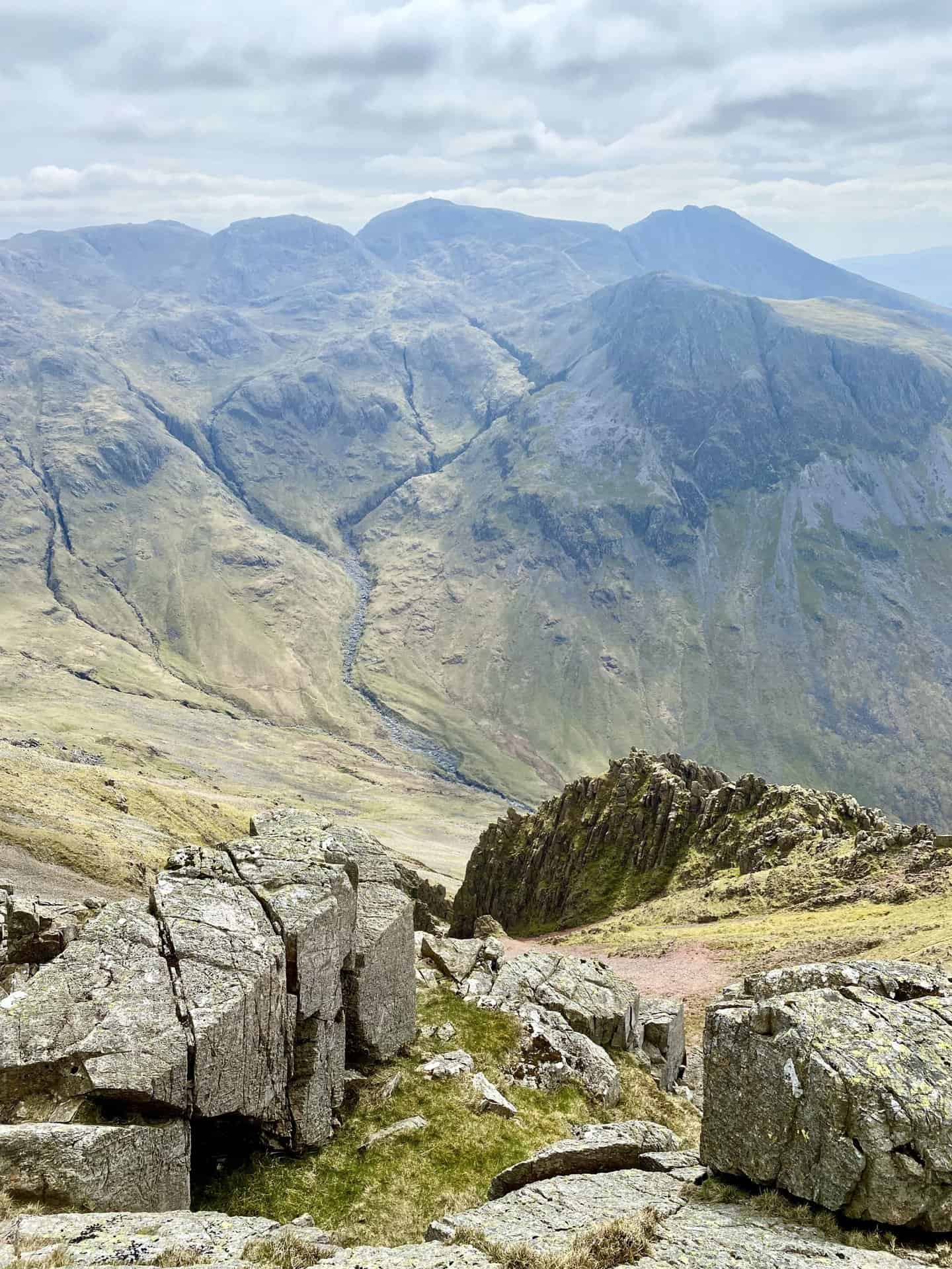 The view south from Westmorland Cairn towards Scafell Pike (centre, horizon). To the right of Scafell Pike is Sca Fell and to the left is Broad Crag and Ill Crag. Lingmell sits in front of Sca Fell. 