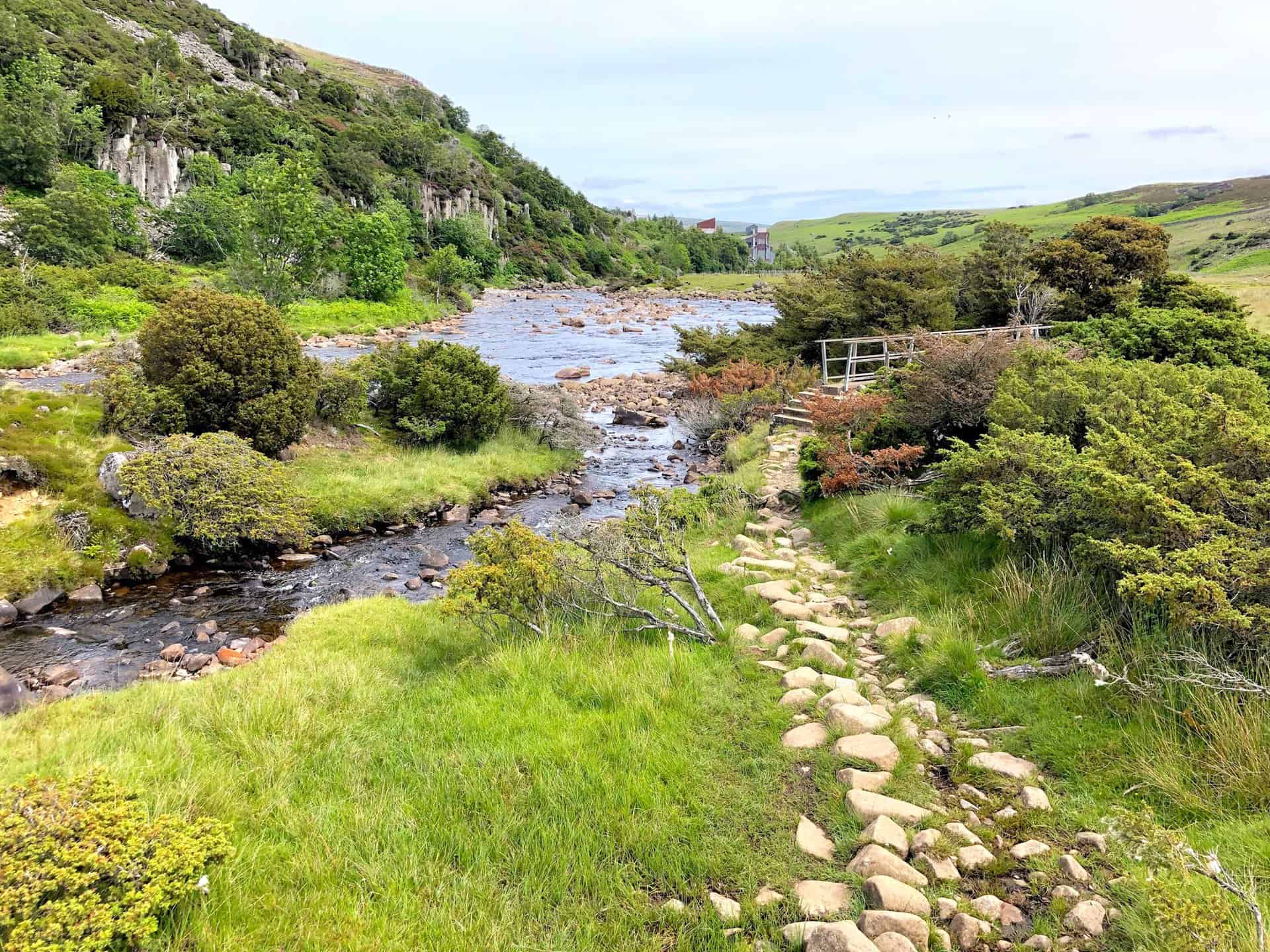 The Pennine Way meanders alongside the River Tees, offering a serene path below the towering Dine Holm Scar.