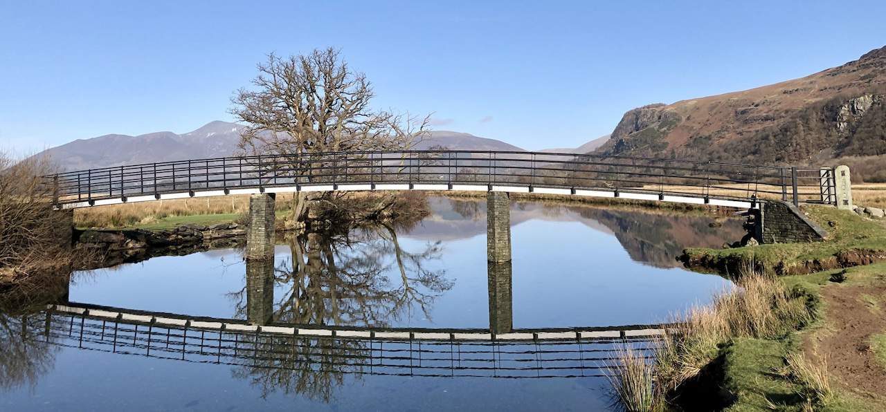 A footbridge across the River Derwent near Great Bay, offering a picturesque crossing for those on the Derwent Water circular walk.
