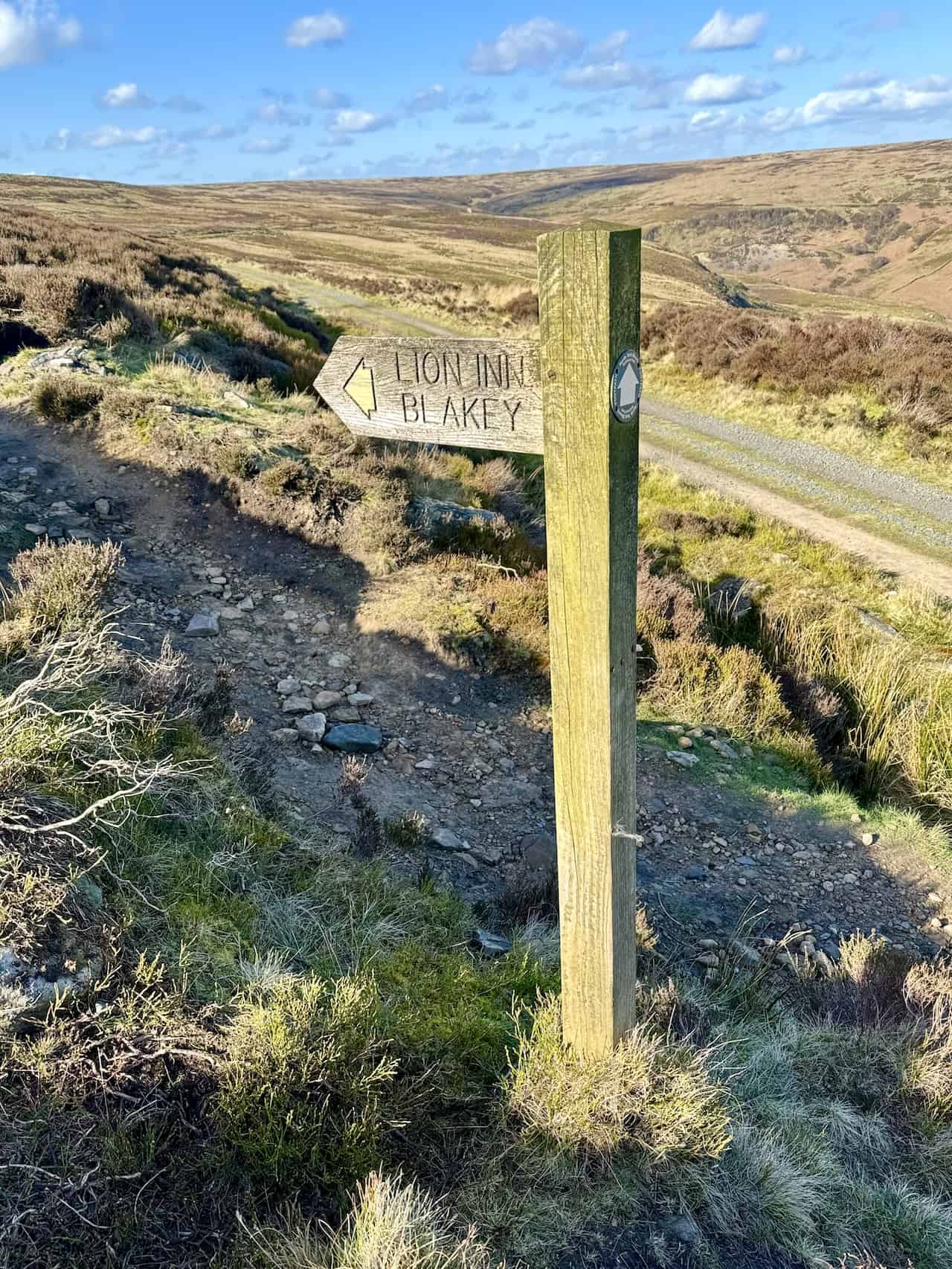 The Rosedale Railway walk concludes with a footpath leading off the trackbed of the old railway, signposted towards the Lion Inn Blakey, marking a memorable end to this scenic journey.