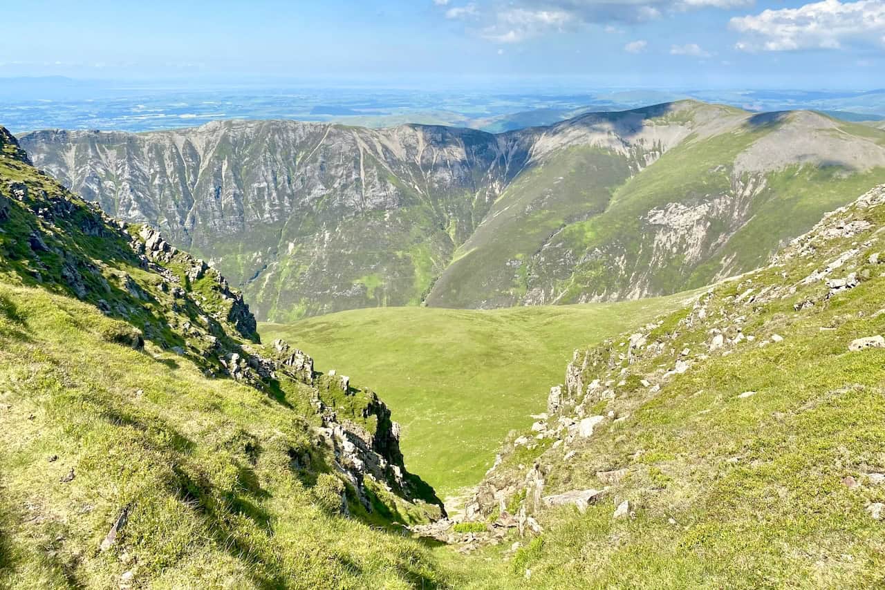 Views from the path above Dove Crags close to the summit of Grasmoor. Beyond Whiteside to the north, the Solway Firth and the mountains of south-west Scotland are visible.
