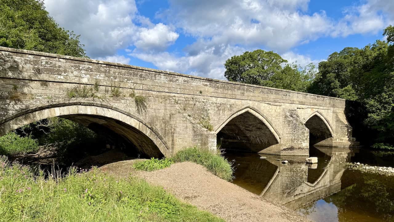 Wensley Bridge spans the River Ure with a blend of medieval and later stone arches. This is the start of the Tupgill Park walk.
