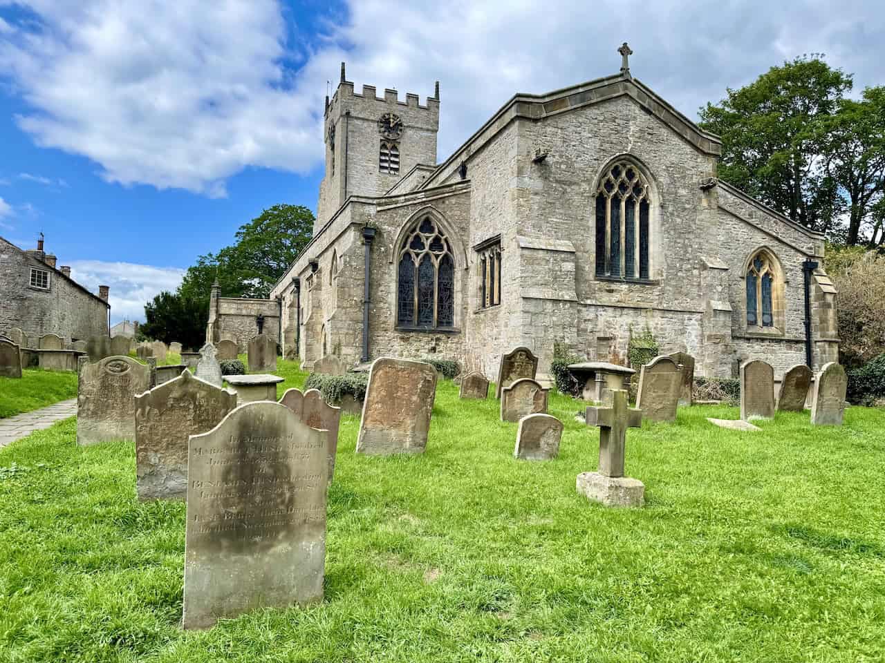 Gravestones and flagged paths line the route through Middleham’s historic churchyard.
