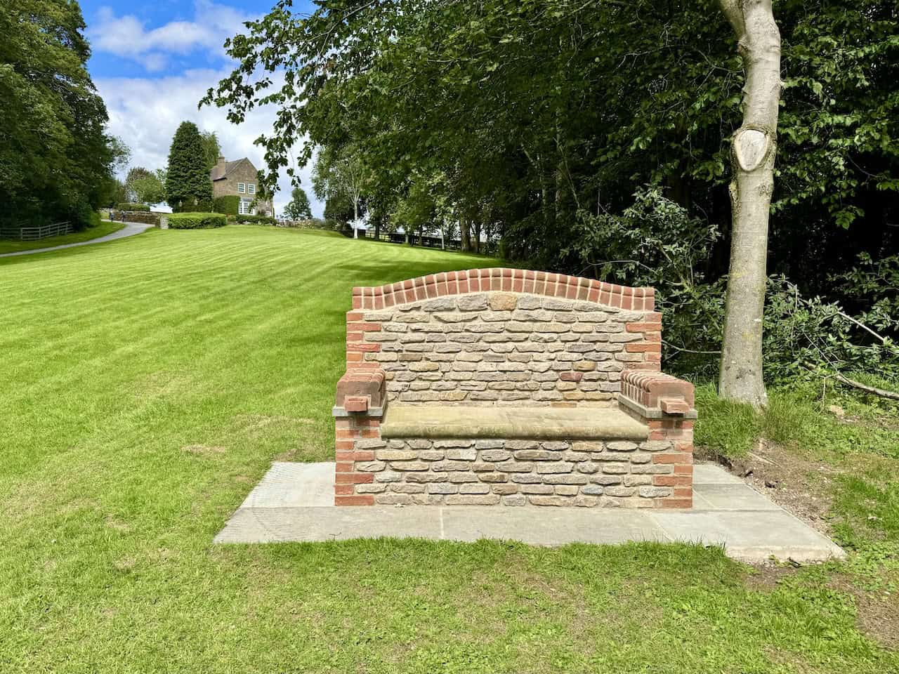‘Leo’s Seat’ is a quiet memorial bench set beside a tree-lined lawn.
