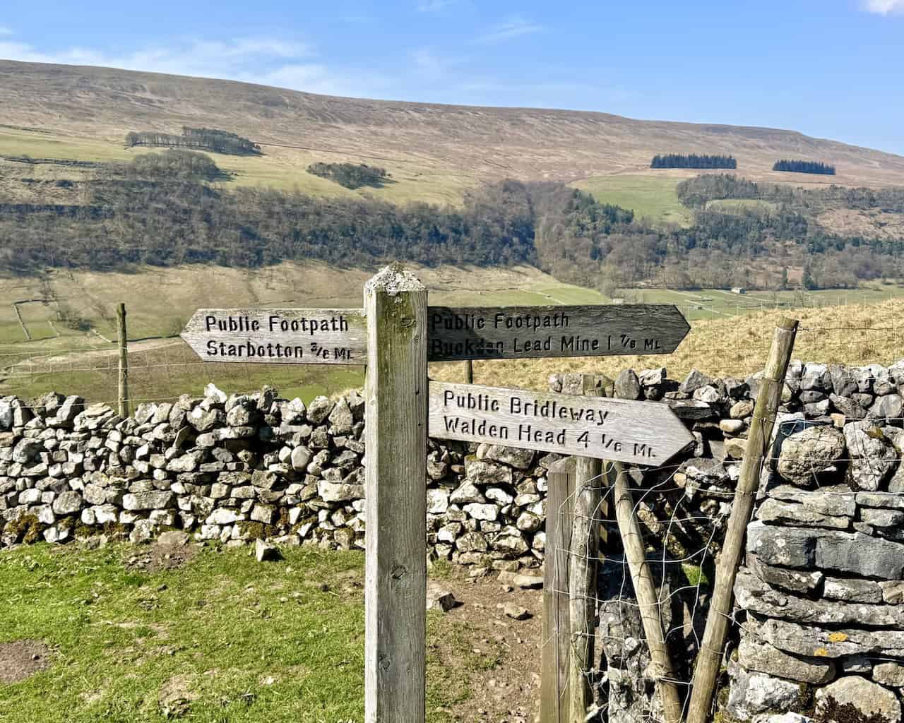 Signpost with very precise distances for nearby footpaths.