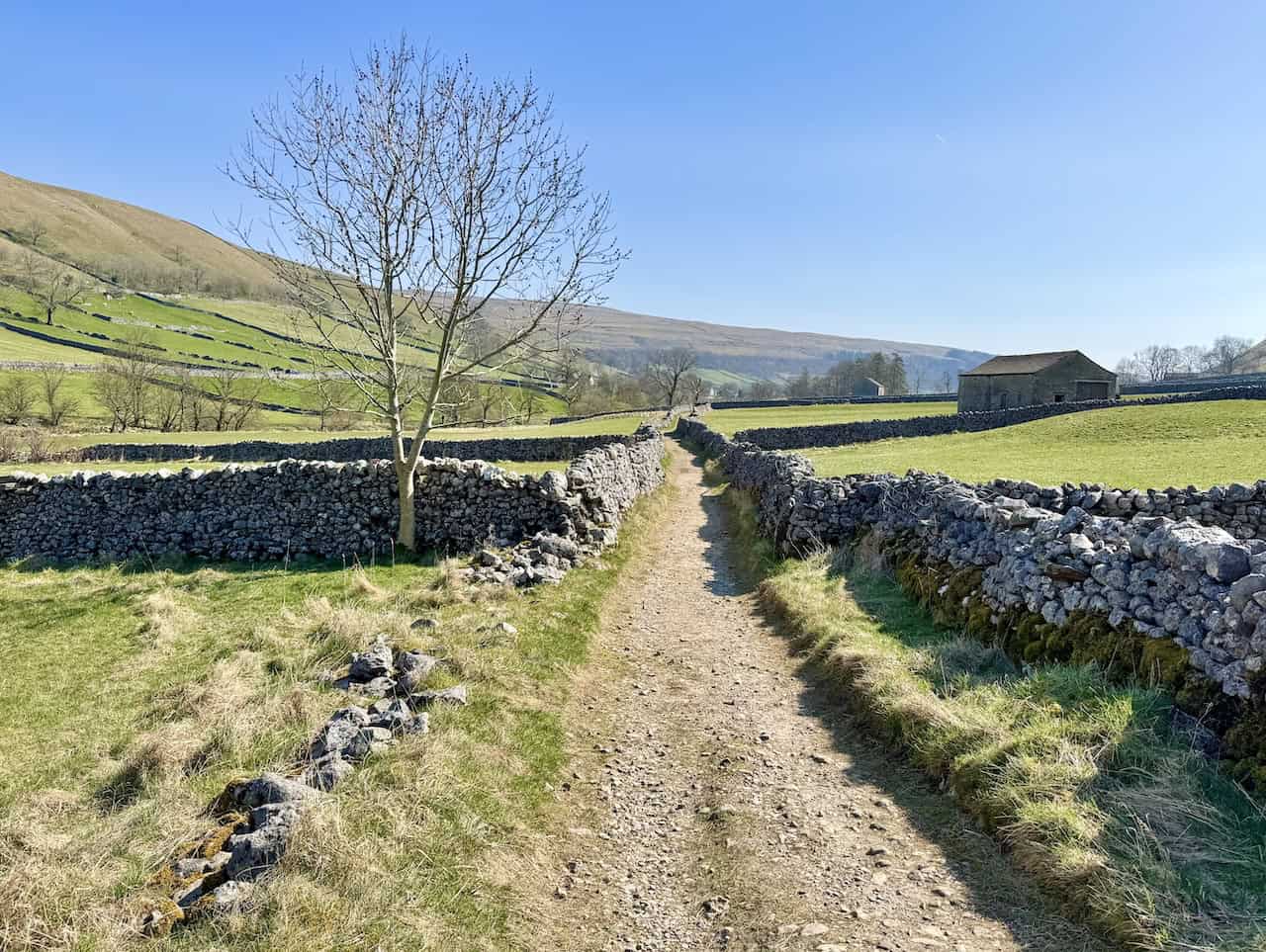Stony track on the way to Kettlewell across open countryside.