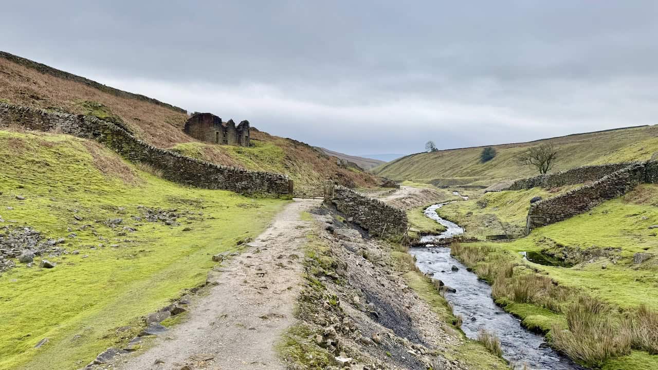 The path following the course of Hebden Beck, with the visible remains of old lead mine workings on the hillside above.