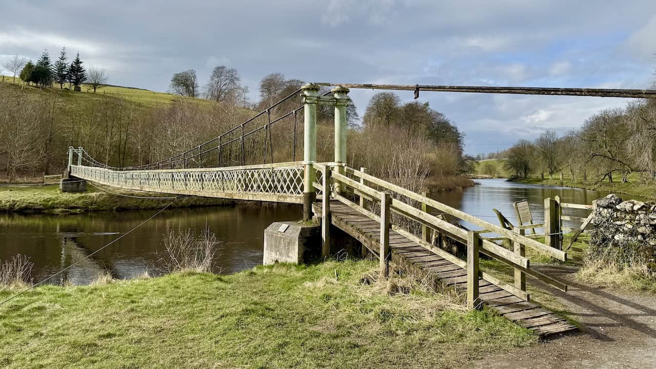 The approach to Hebden Suspension Bridge over the River Wharfe, built by local blacksmith William Bell in 1885 and paid for by public subscription.