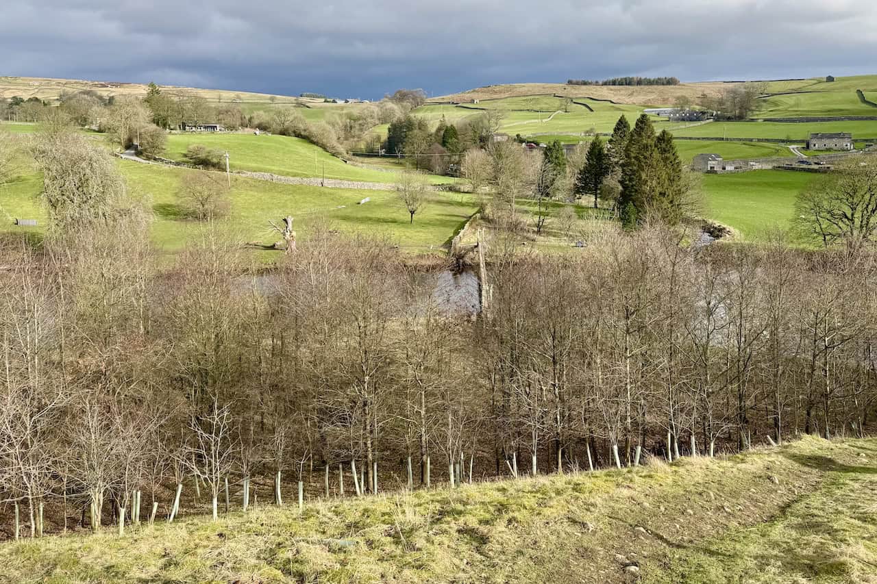 The footpath crossing open fields on the Grassington circular walk, with the village of Thorpe and the surrounding reef knolls visible in the distance.