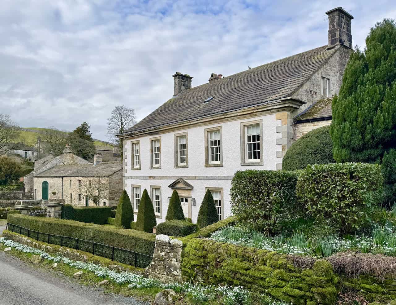 The quiet lane leading into the secluded hamlet of Thorpe, sheltered by the reef knolls of Elbolton Hill and Kail Hill in Wharfedale.