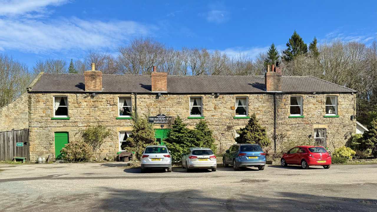 Hayburn Wyke Inn beside the Cinder Track, a stone-built coaching inn with distinctive green paintwork and a long history of serving travellers.