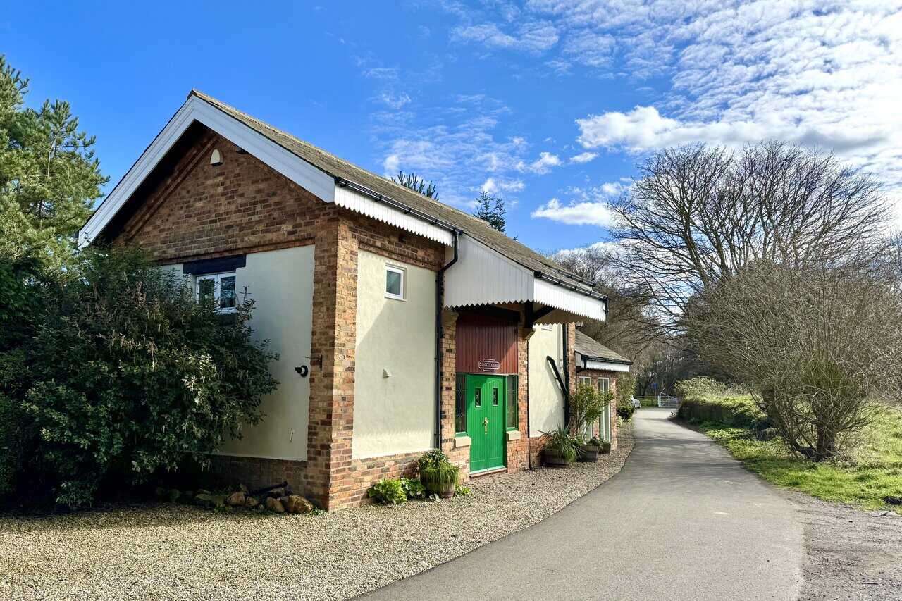 Old Goods Shed at Cloughton Station, renovated into self-catering accommodation with brick detailing, green door and corrugated canopy.