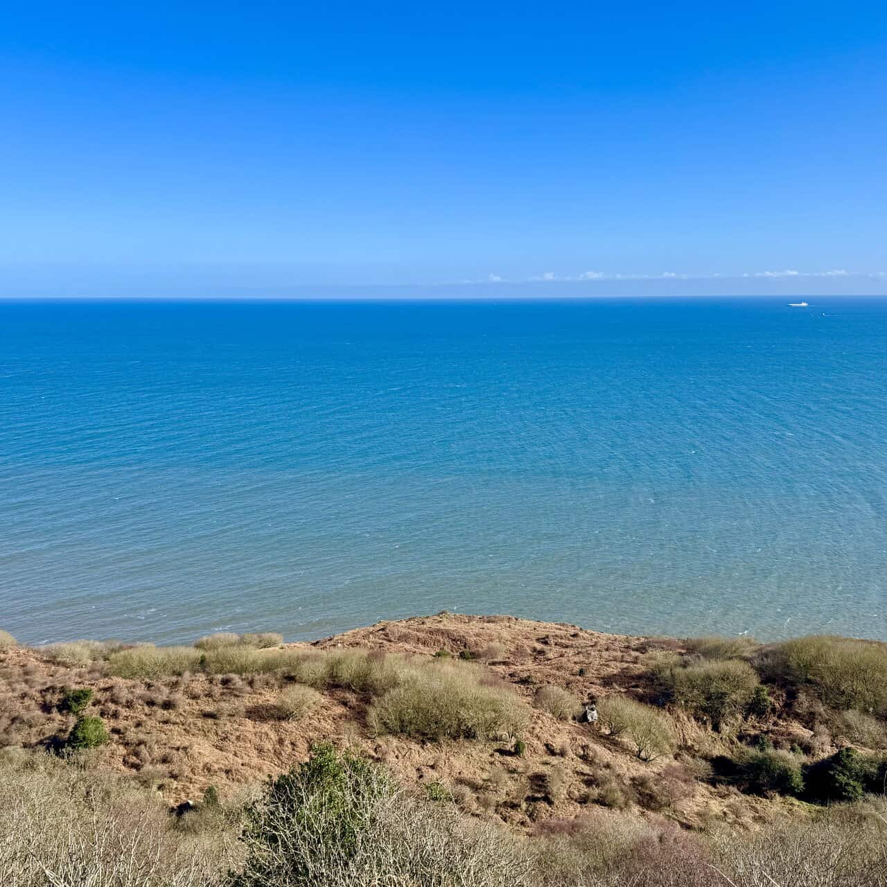 Calm North Sea with a single cargo ship on the distant horizon.