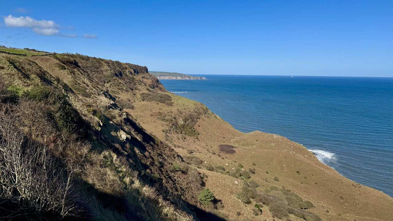 Clifftop path north of Ravenscar, with distant views towards the cliffs beyond Robin Hood’s Bay.