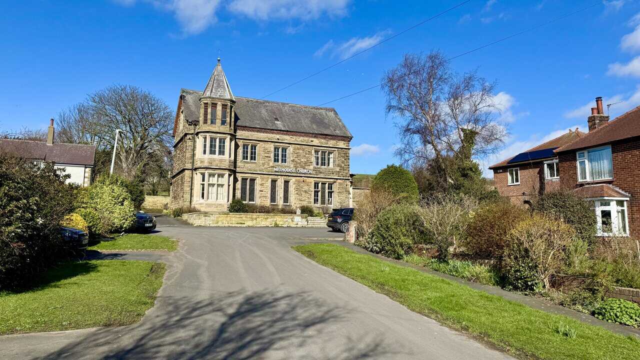 Methodist Church at the end of Wesley Road, a handsome stone building with a small turret and large arched windows.