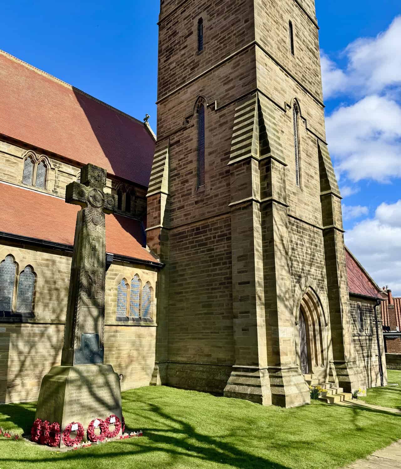 Rear and side view of St Stephen’s Church, showing the memorial cross and the churchyard beside the Cinder Track.