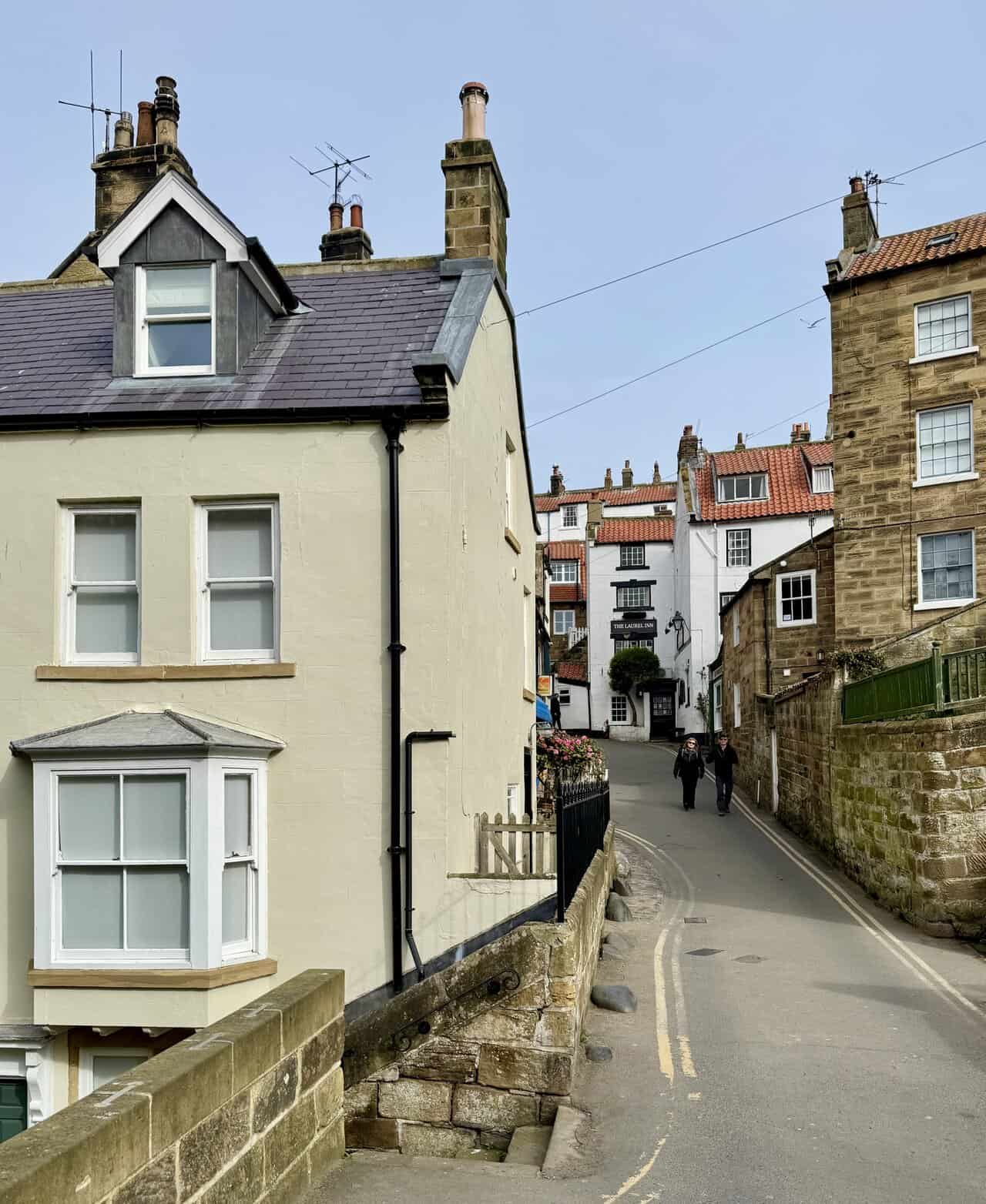 Steep village lane with stone cottages and The Laurel Inn on the Robin Hood's Bay walk.