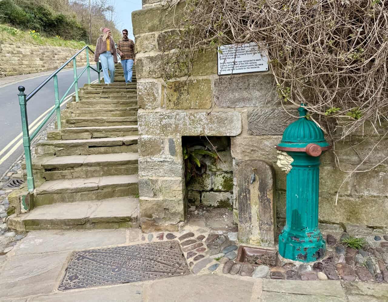Restored Victorian cast-iron water fountain set beside stone steps in Robin Hood’s Bay.