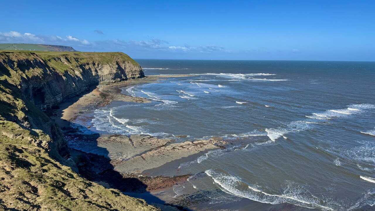 Old Nab headland jutting into the sea, with sharply exposed layers of sandstone and mudstone above the rocky shore.