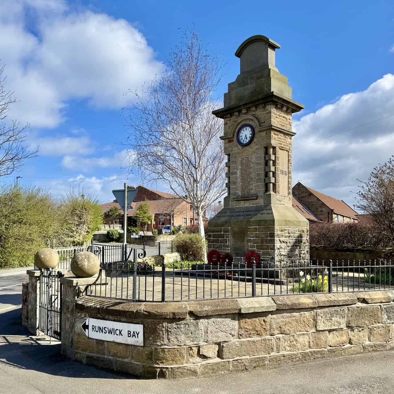 Hinderwell war memorial on the Runswick Bay walk, a sandstone clock tower standing at the junction where the road turns towards Runswick Bay.