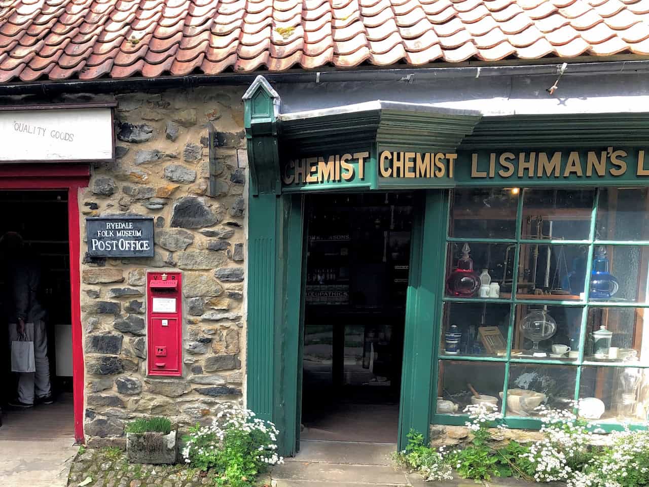 The Vintage Chemist at Ryedale Folk Museum, recreating an early 20th-century pharmacy with shelves of traditional cobalt blue bottles for syrups and green bottles for poisons, alongside curiosities such as leech bowls.