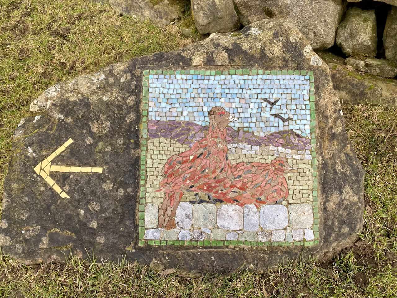 The Red Grouse mosaic set beside a dry stone wall in the Dallowgill countryside.