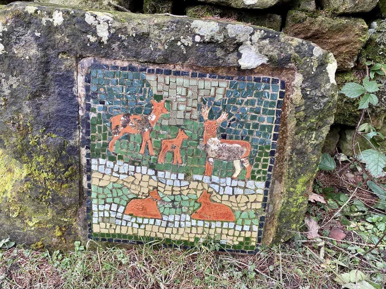 The Deer mosaic sits in a quiet woodland clearing reached after crossing a footbridge.