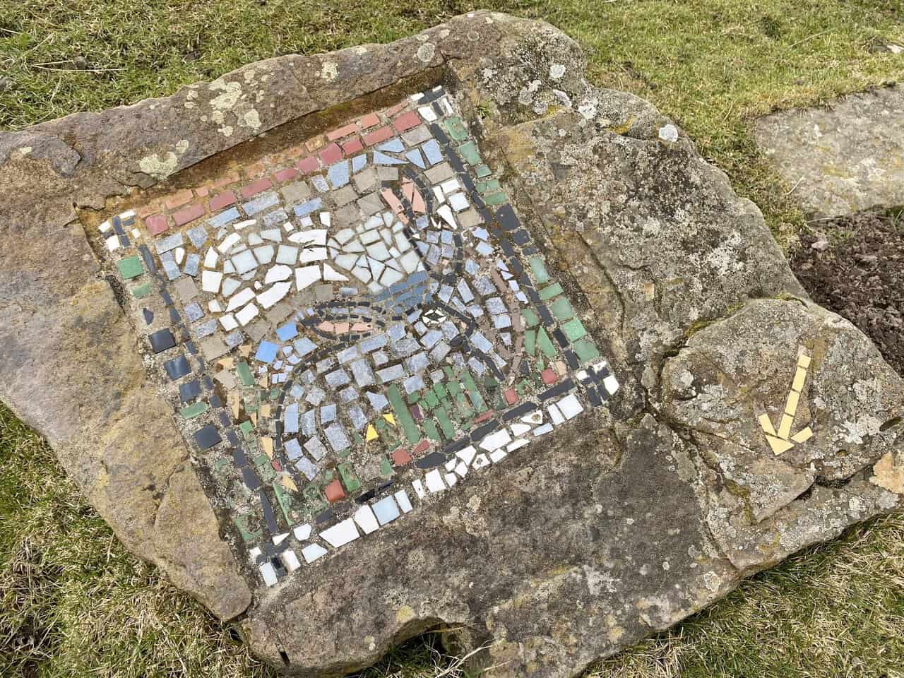 The Rabbits mosaic is found after climbing uphill from the woodland track.