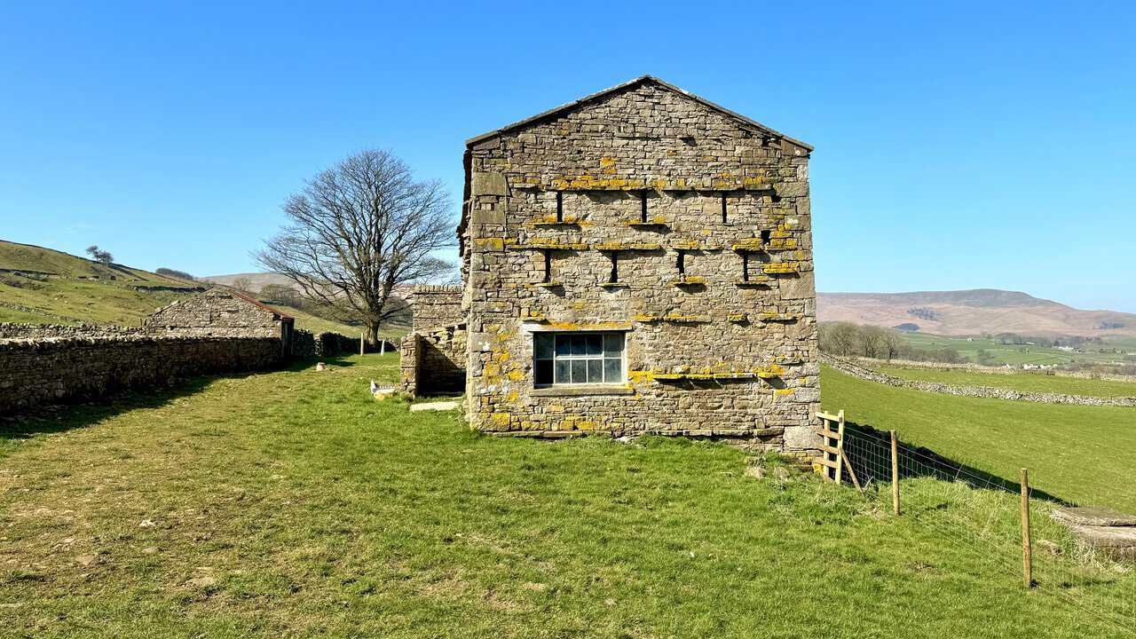Walking across open countryside on the way from Burtersett towards Gayle, with dry stone walls and fields stretching ahead.