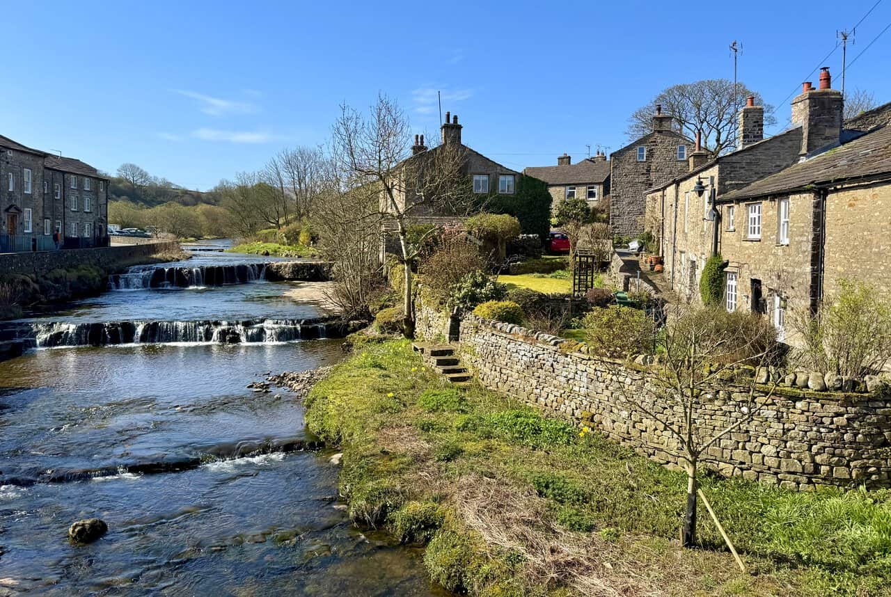 Gayle Beck running through the village of Gayle, framed by stone buildings and the surrounding dale landscape.