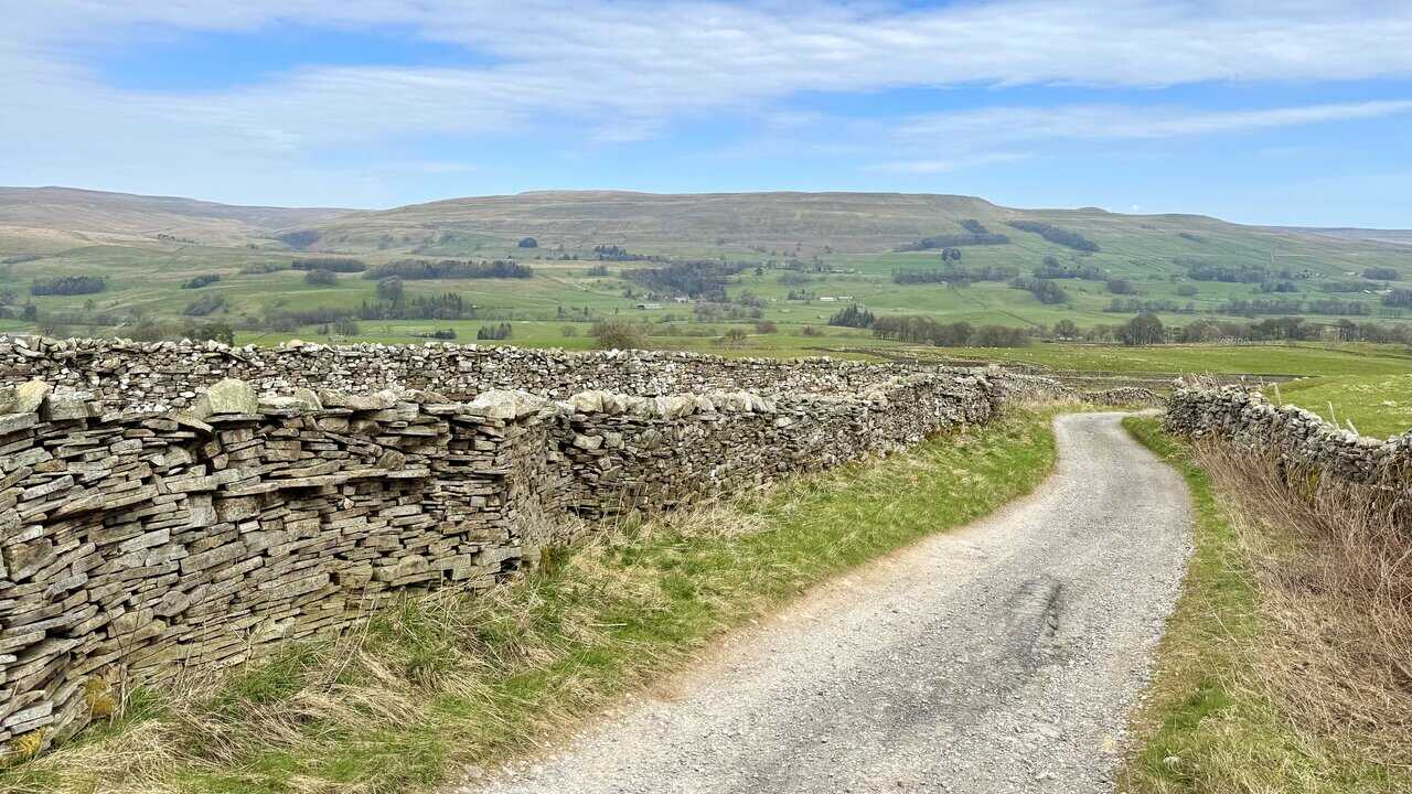 Heading down from Bands Lane towards the main road, with rolling fields and stone walls on either side.