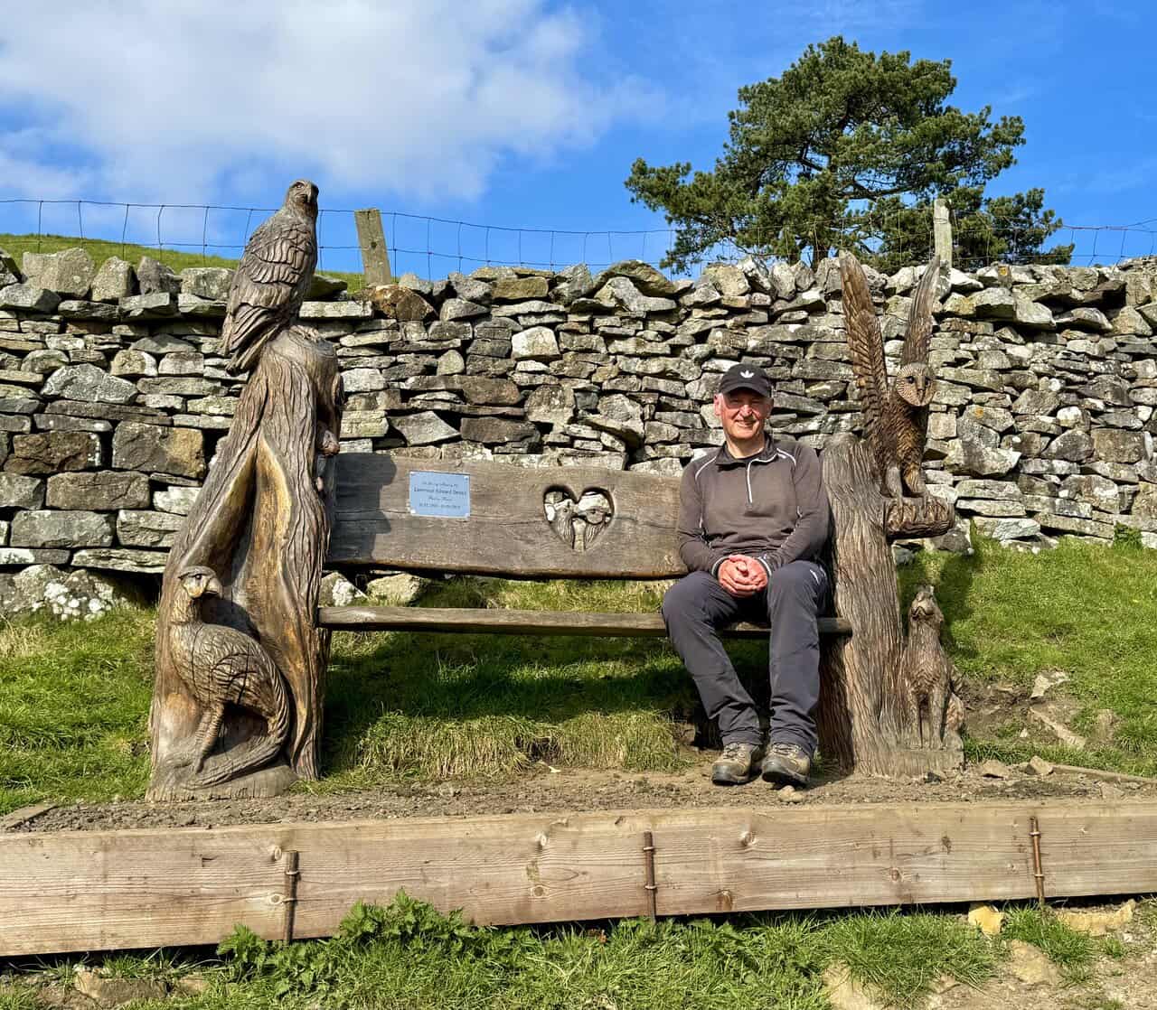 Ornate wooden bench beside the footpath on the climb up towards Simonstone.