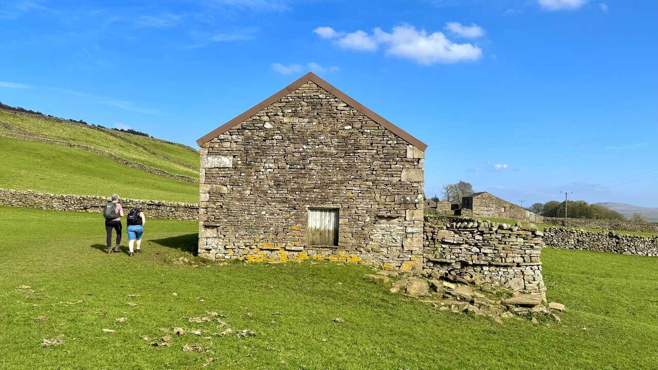Stone barns and dry stone walls lining the route on the approach to Sedbusk.