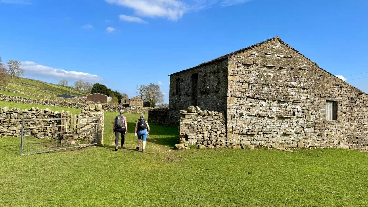 Passing stone barns and dry stone walls on the way to Sedbusk along a quiet section of the Hawes Mosaic Trail.