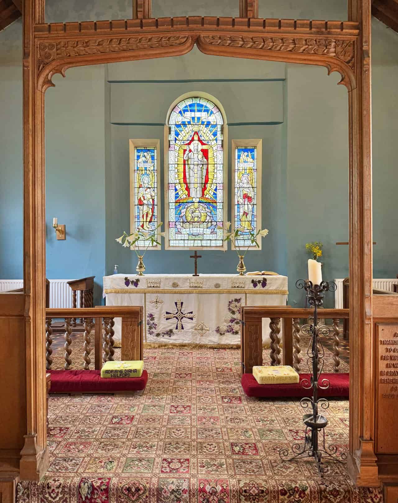 Inside St Hilda’s Church, oak pews and patterned flooring lead towards the chancel.