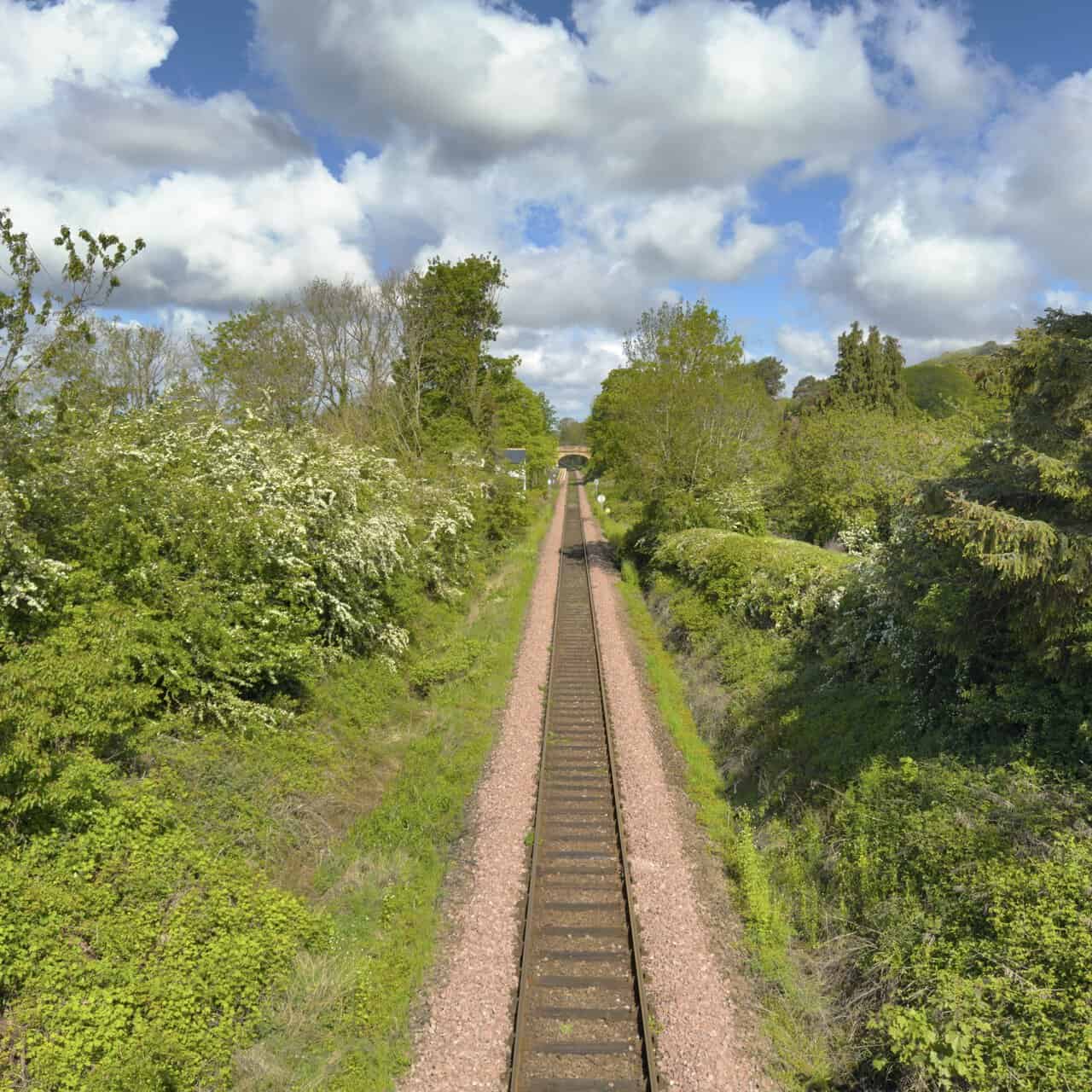 A railway line runs straight through a leafy cutting near Great Ayton, viewed from a high bridge beyond Fletcher’s Farm Coffee Shop.