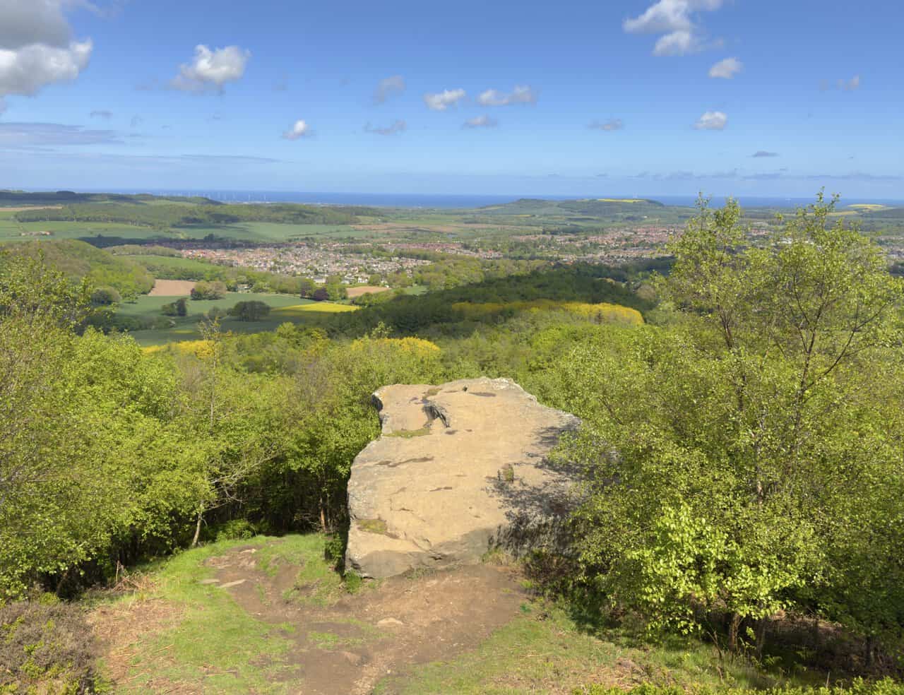 Hanging Stone forms a dramatic sandstone outcrop on the Great Ayton walk above Guisborough, with sweeping views across wooded slopes, fields and the distant North Sea.
