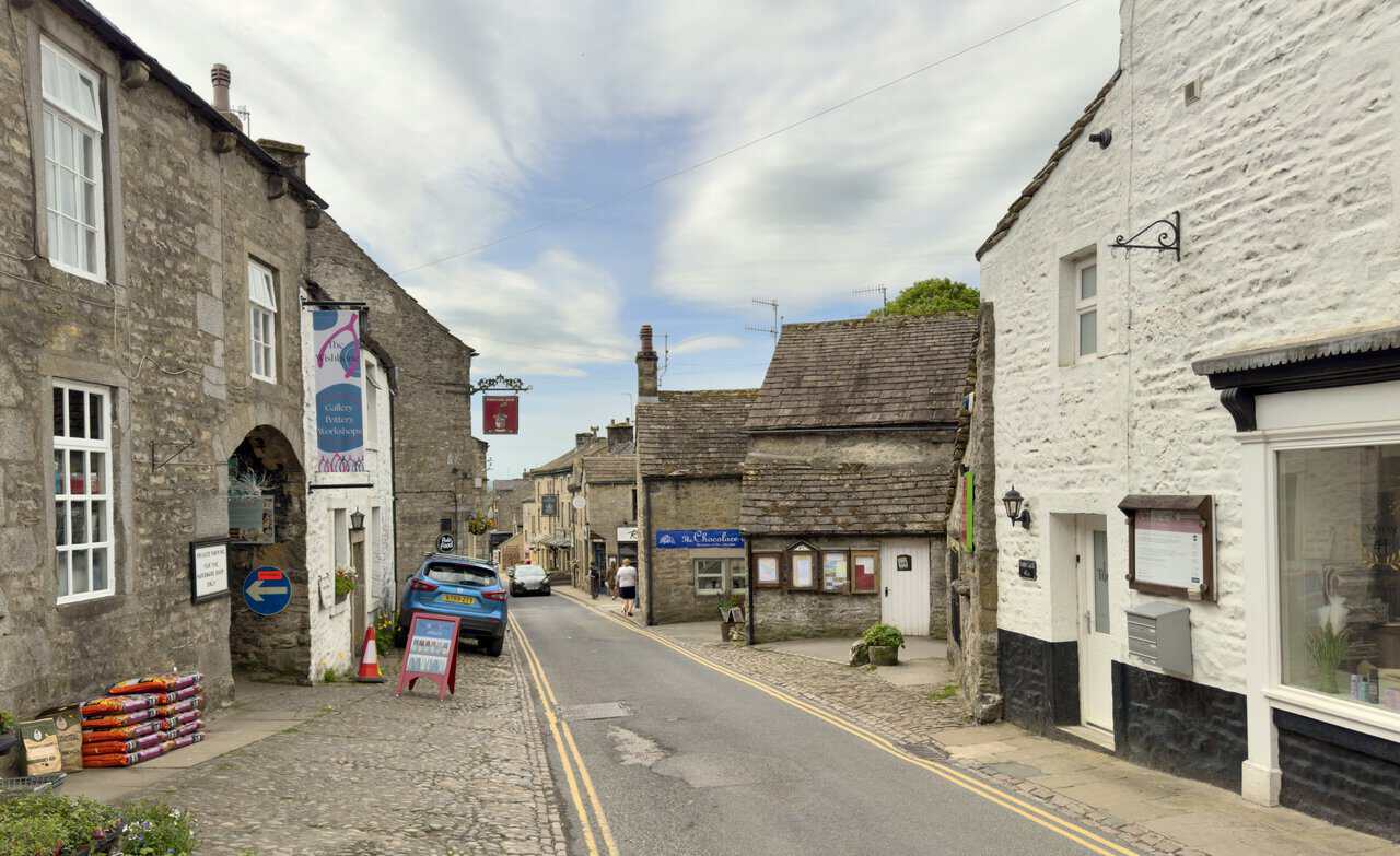 Independent shops and traditional stone buildings along Main Street in Grassington, including galleries, cafés and pubs.