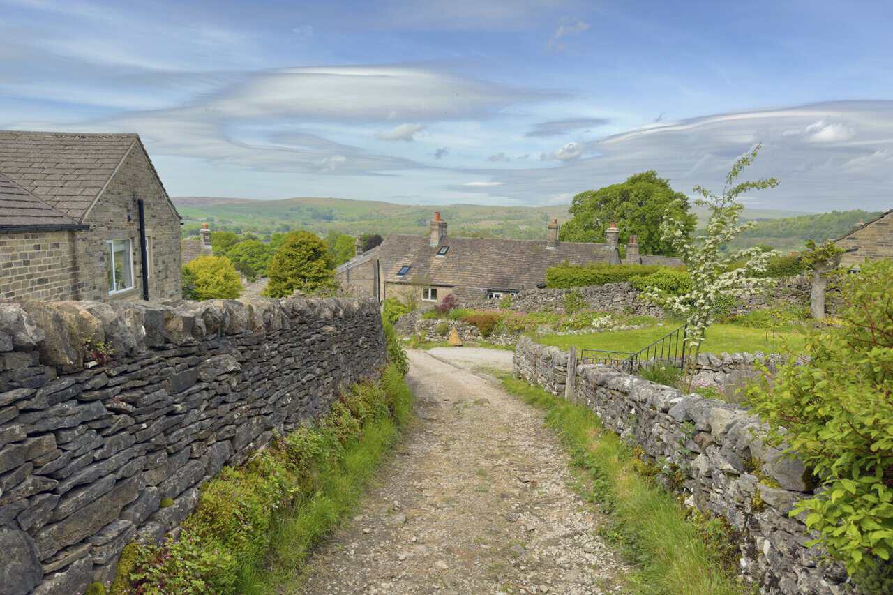 Stone cottages with weathered slate roofs at the upper edge of Grassington, where High Lane meets Low Lane.