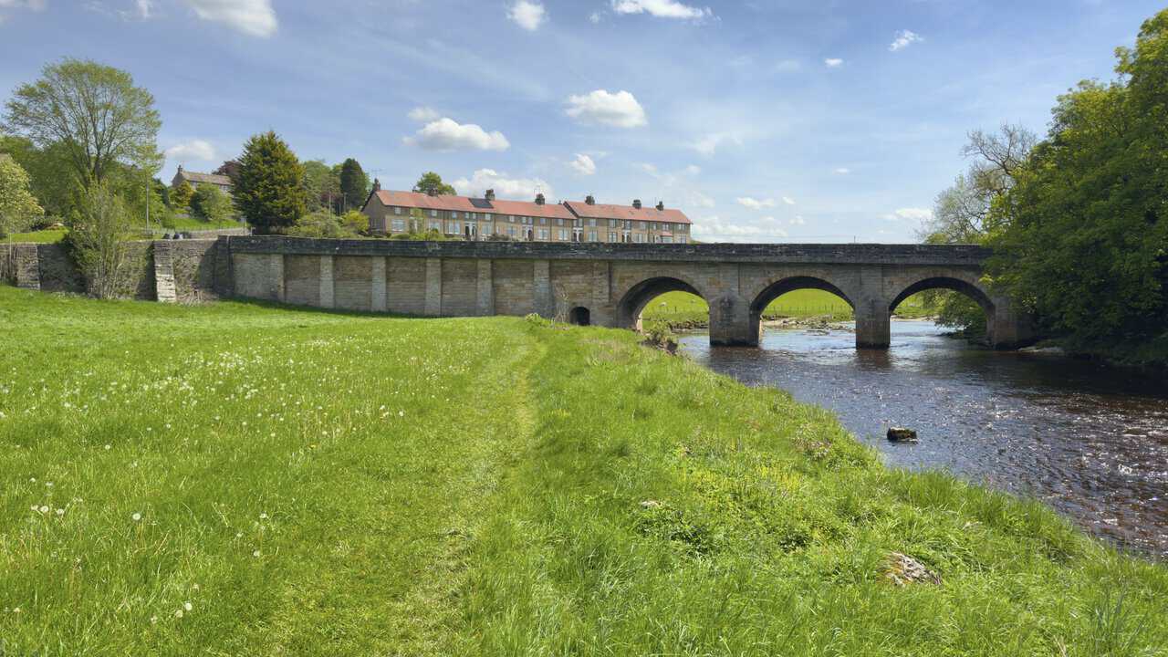 The arched stone road bridge carrying the B6265 across the River Wharfe between Grassington and Threshfield on this Hebden walk.