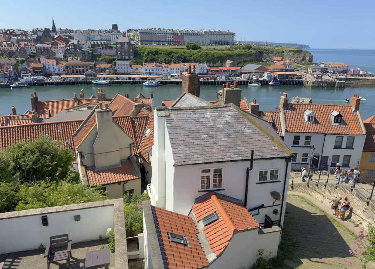 The 199 Steps descend from St Mary's Church towards Whitby old town, with red pantile roofs and the harbour below.