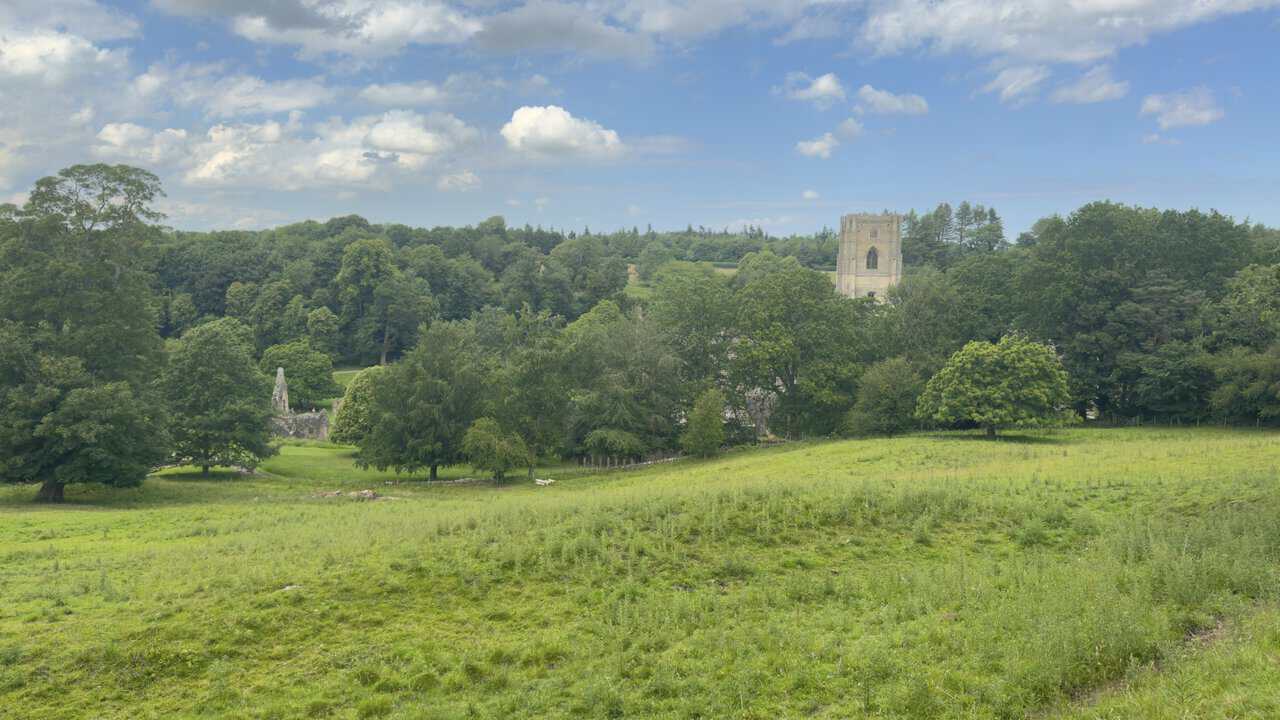 Distant views of Fountains Abbey from the bridleway beside the ancient abbey wall near Hill House Farm.