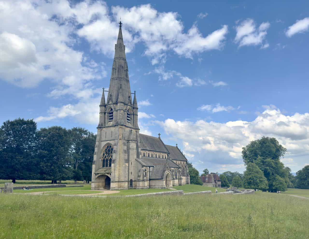 St Mary’s Church in Studley Royal Deer Park, with its pale stone Gothic spire rising above open parkland.