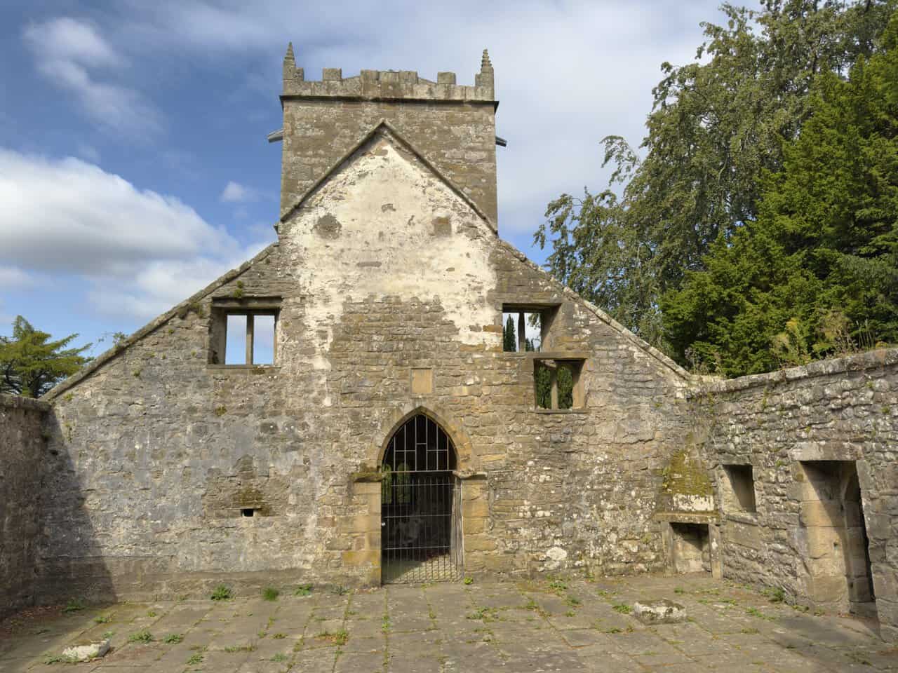 Roofless interior of Saint Mary’s Church, with ledger stones, ruined walls and open sky above.
