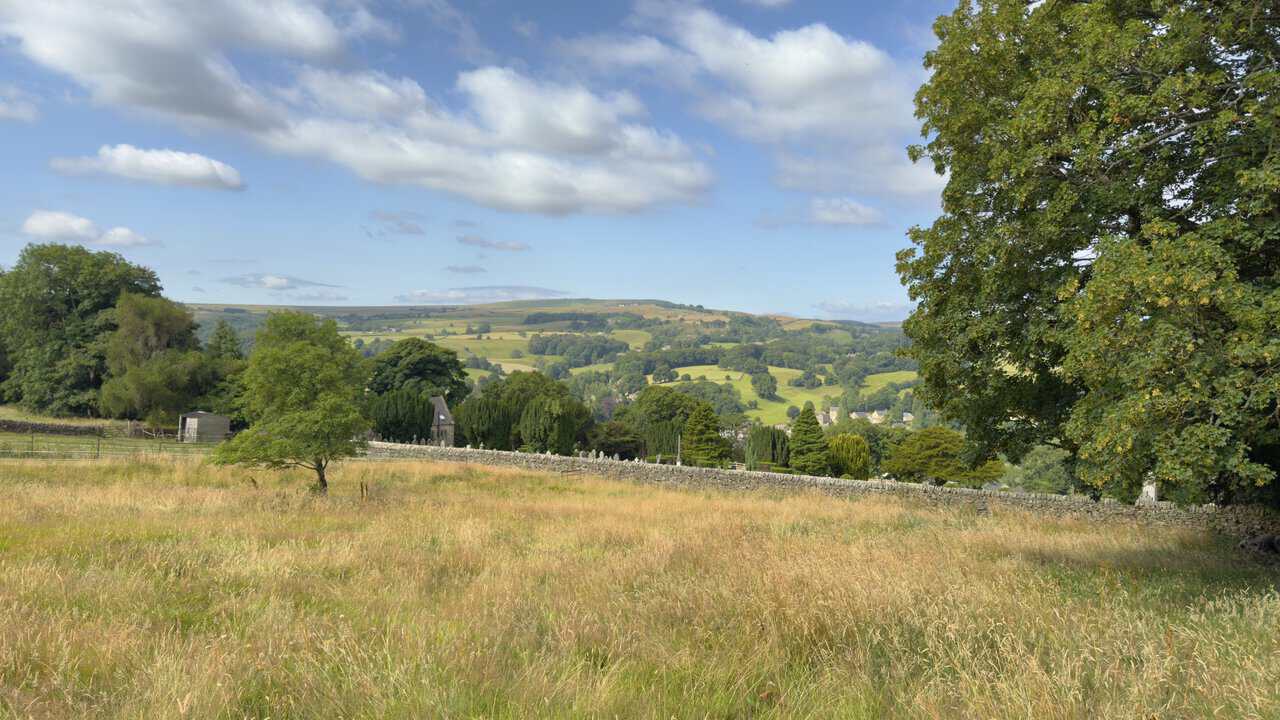 Cemetery, fields and wooded hills across Nidderdale from the Brimham Rocks walk.